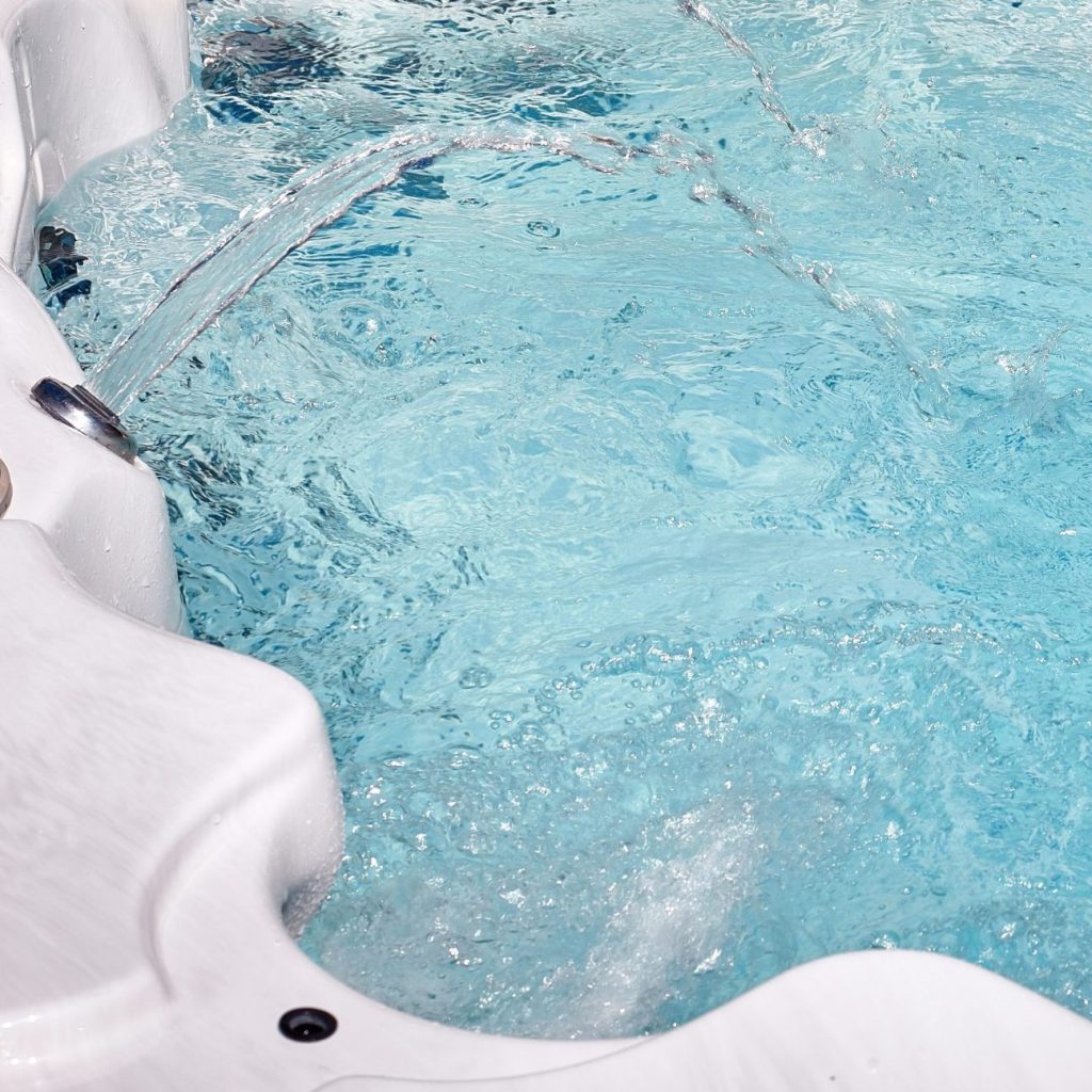 Luxury hot tub with clear bubbling water. Spa massage concept.